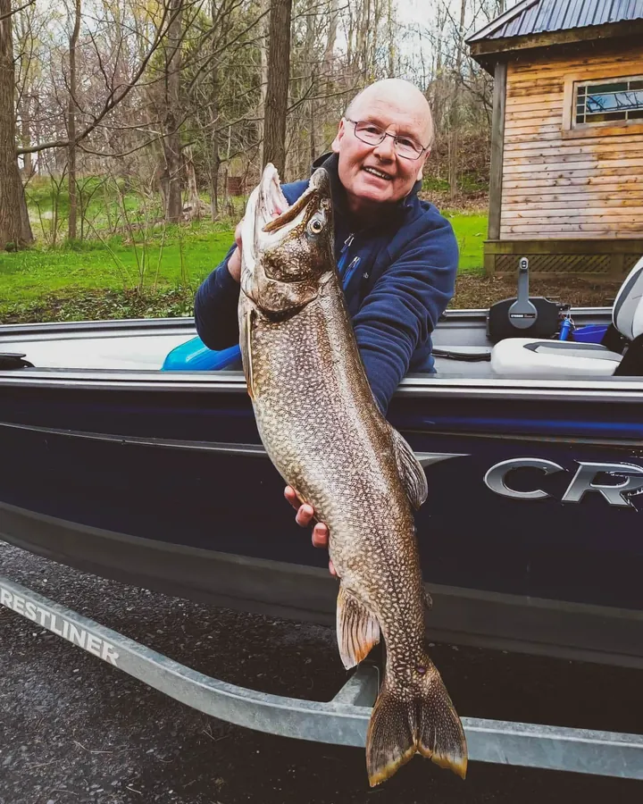 Pêcheur en bateau guidé avec une truite sur le lac Memphrémagog, Cantons-de-l'Est